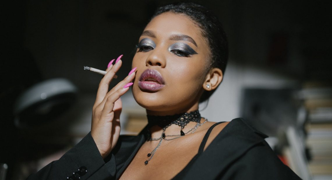 woman in black blazer holding cigarette stick